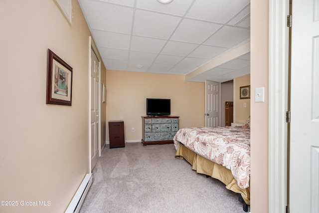 bedroom featuring a baseboard heating unit, a paneled ceiling, baseboards, and light colored carpet
