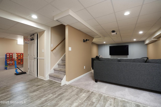 living room with a drop ceiling, baseboards, recessed lighting, wood finished floors, and stairway