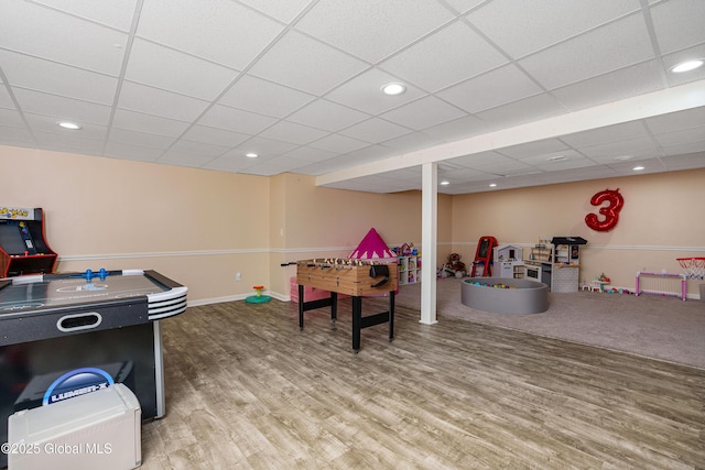 game room featuring baseboards, wood finished floors, a paneled ceiling, and recessed lighting