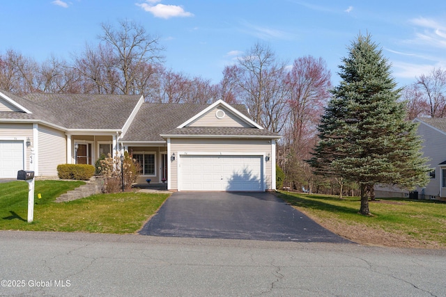 view of front of house featuring an attached garage, aphalt driveway, and a front yard