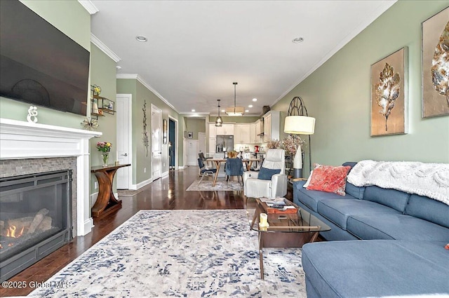 living area featuring crown molding, recessed lighting, a glass covered fireplace, and dark wood-style floors