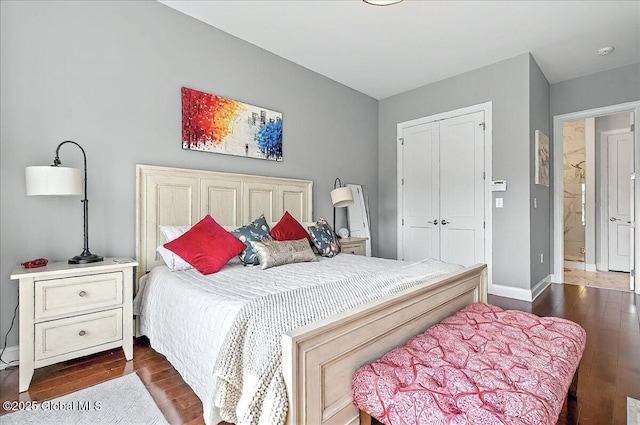bedroom with baseboards, a closet, and dark wood-style flooring