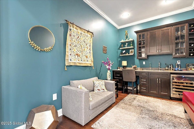 interior space with crown molding, dark wood-style flooring, a sink, beverage cooler, and bar area