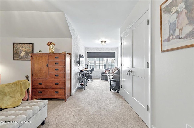 sitting room with baseboards and light colored carpet