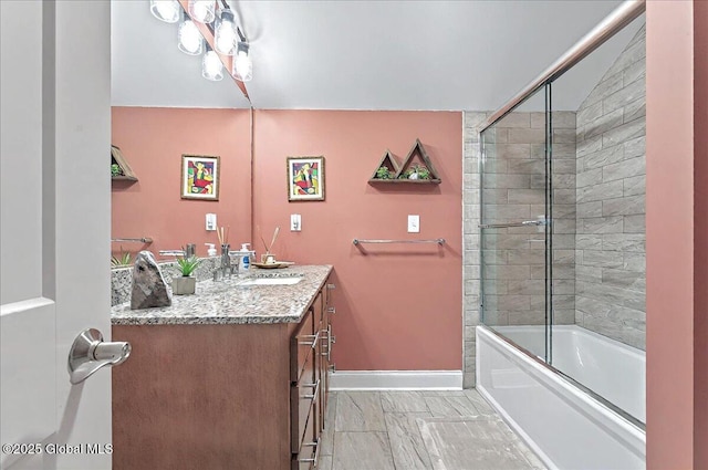 full bathroom with baseboards, bath / shower combo with glass door, and vanity