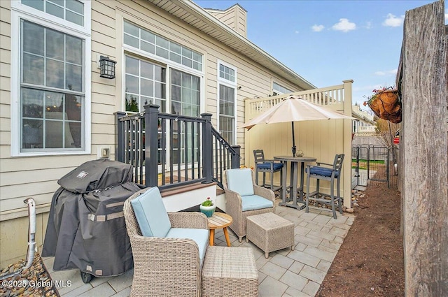 view of patio / terrace with fence, outdoor dining area, and a grill
