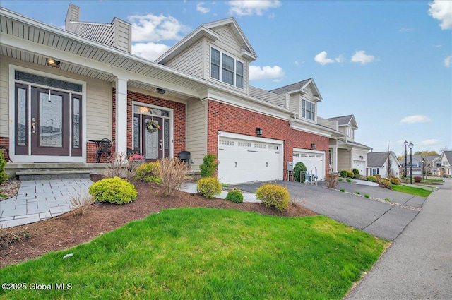 view of property exterior with covered porch, a chimney, brick siding, an attached garage, and driveway