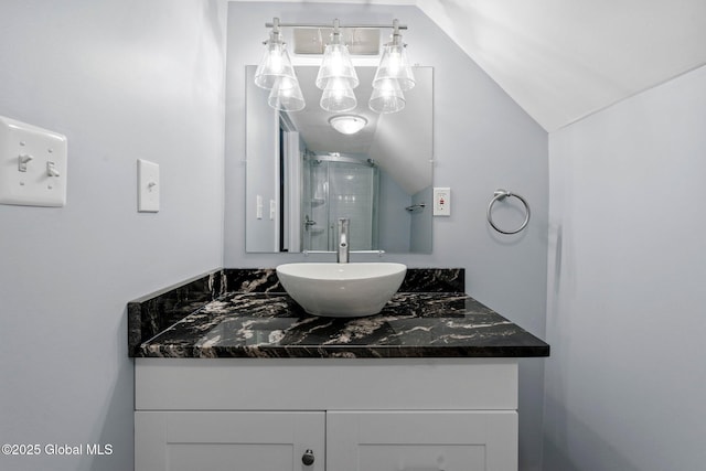 bathroom with vanity, a shower with shower door, and lofted ceiling