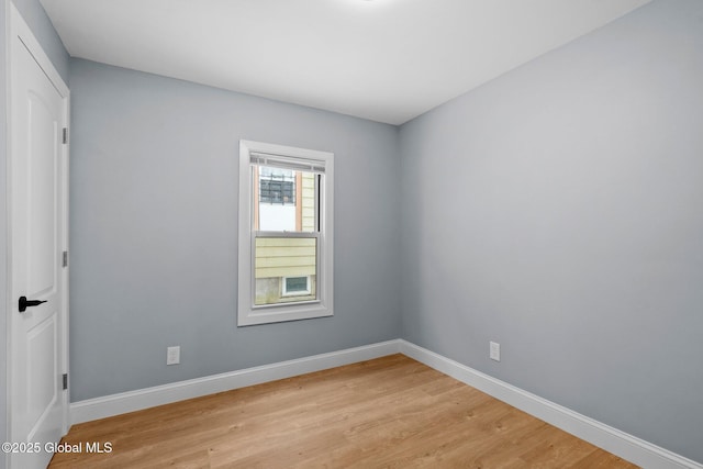 empty room featuring baseboards and light wood-type flooring