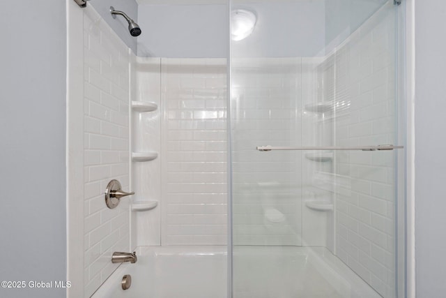 bathroom with bath / shower combo with glass door