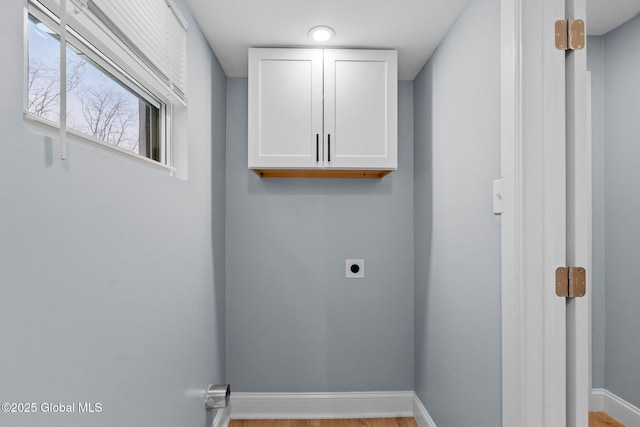 laundry room with cabinet space, baseboards, electric dryer hookup, and wood finished floors