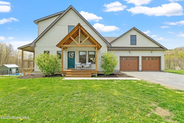 modern inspired farmhouse featuring covered porch, a standing seam roof, driveway, and a front lawn