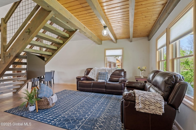 living room with baseboards, beam ceiling, wood finished floors, and stairway