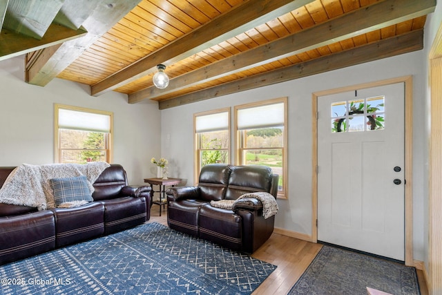 living room with baseboards, beamed ceiling, hardwood / wood-style floors, and wooden ceiling