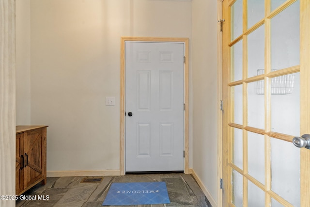 doorway to outside with baseboards and visible vents