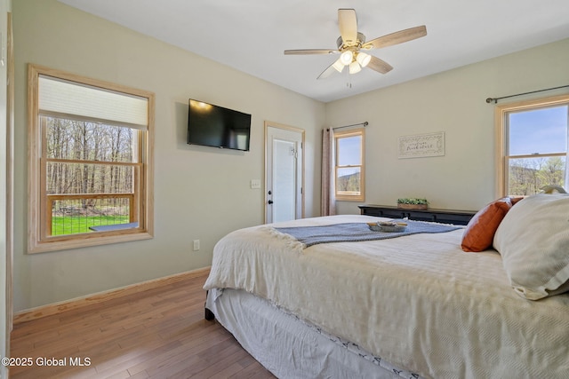 bedroom featuring baseboards, a ceiling fan, and wood finished floors