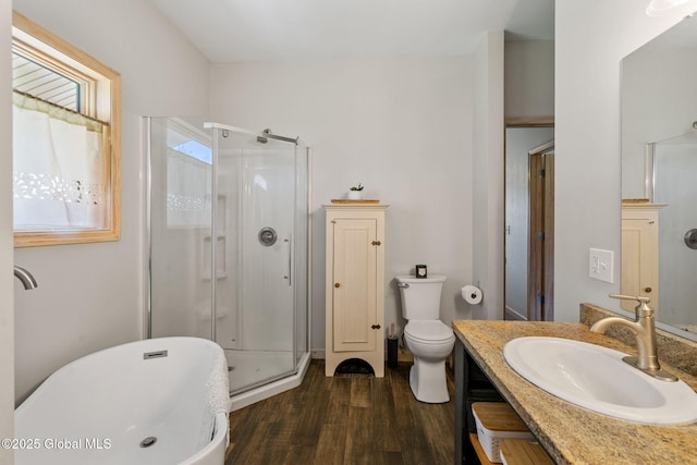 full bathroom featuring vanity, a shower stall, toilet, and wood finished floors
