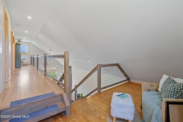 interior space with vaulted ceiling, hardwood / wood-style flooring, baseboards, an upstairs landing, and recessed lighting