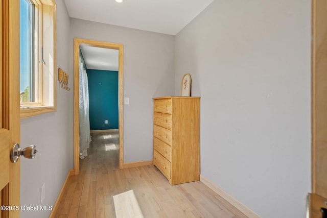 hall featuring baseboards and light wood-style floors