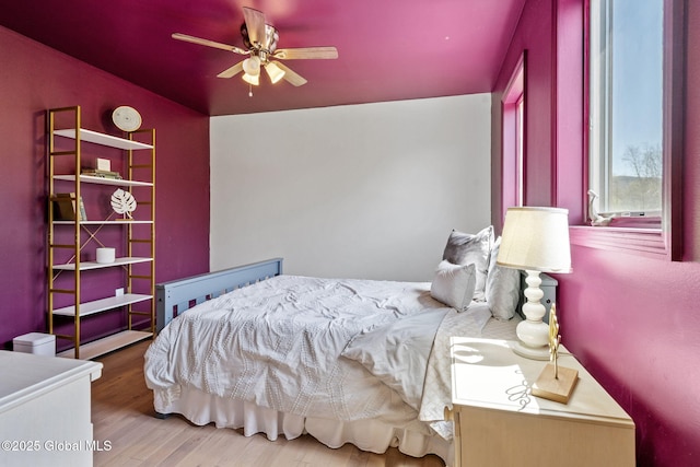 bedroom featuring a ceiling fan, vaulted ceiling, and wood finished floors