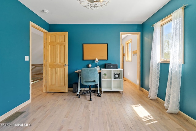 office area with baseboards, hardwood / wood-style flooring, and visible vents