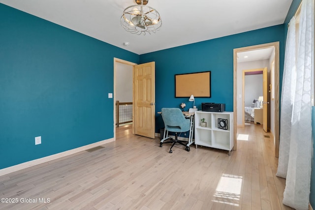 office featuring baseboards, visible vents, wood finished floors, and a notable chandelier
