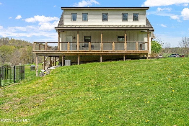 rear view of house with a standing seam roof, a wooden deck, a yard, and central air condition unit