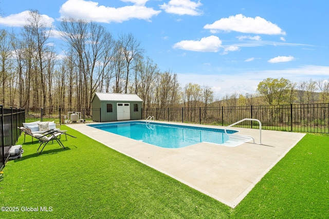 view of pool with a patio, a fenced backyard, a fenced in pool, an outbuilding, and a yard