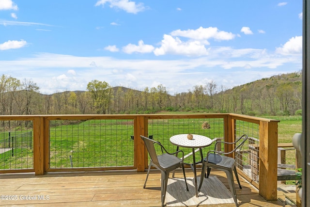 wooden deck with a lawn, a mountain view, and a wooded view