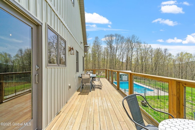 deck featuring a fenced in pool and outdoor dining space