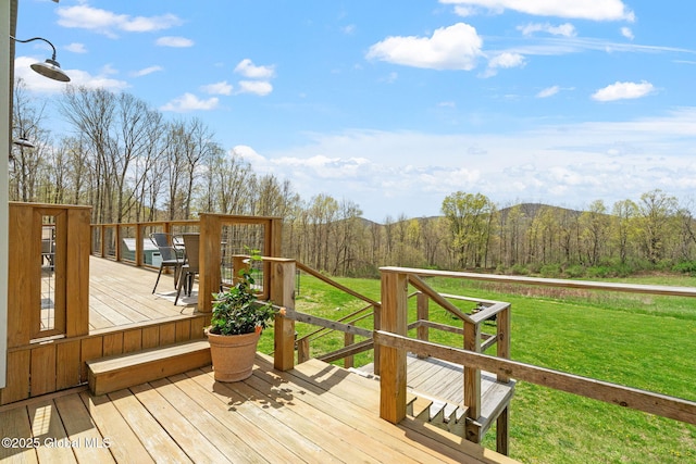 wooden terrace with a lawn and a wooded view