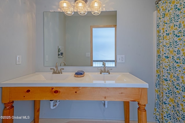 full bathroom featuring double vanity, a sink, and a chandelier