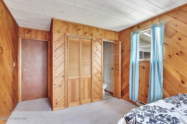 carpeted bedroom featuring baseboard heating, wood walls, and wood ceiling