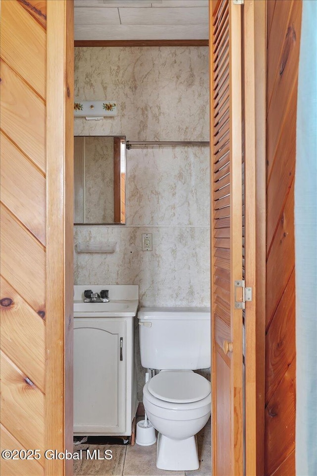 half bath with vanity, washer / dryer, and toilet