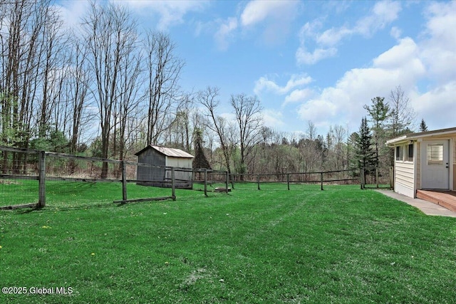 view of yard with a fenced backyard, a shed, and an outbuilding