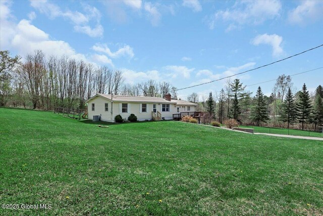 view of front of property featuring a chimney, central AC, and a front yard