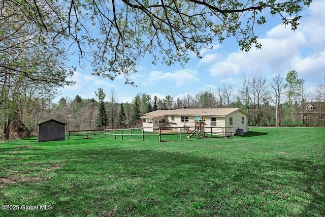 view of yard with a storage unit, an outdoor structure, and fence