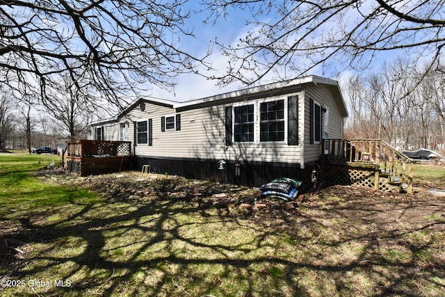 view of home's exterior featuring a yard and a wooden deck