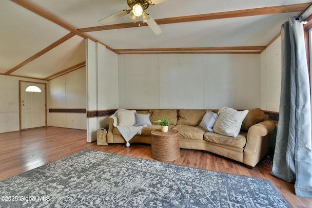 living area featuring vaulted ceiling, a ceiling fan, and wood finished floors