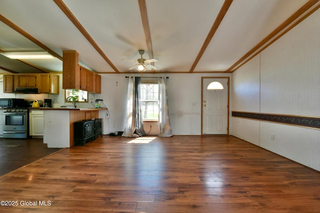 kitchen featuring stainless steel range with gas stovetop, black microwave, a peninsula, a ceiling fan, and dark wood-style floors
