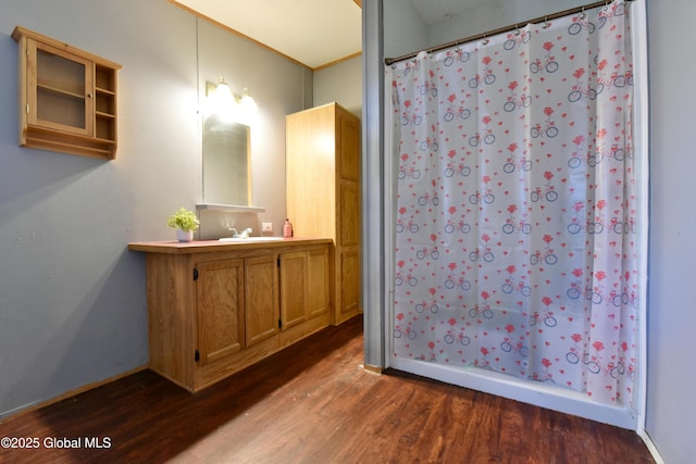 full bathroom featuring baseboards, a shower with shower curtain, vanity, and wood finished floors
