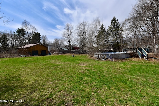 view of yard featuring an outdoor pool, an outbuilding, a garage, and an outdoor structure