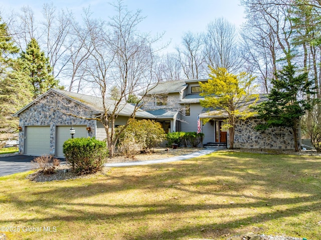 view of front facade with a garage, a front lawn, aphalt driveway, and stone siding