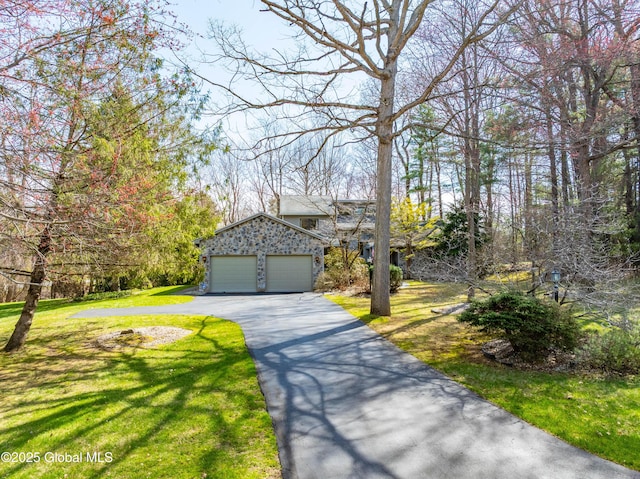 view of front facade featuring a garage, a front lawn, and driveway