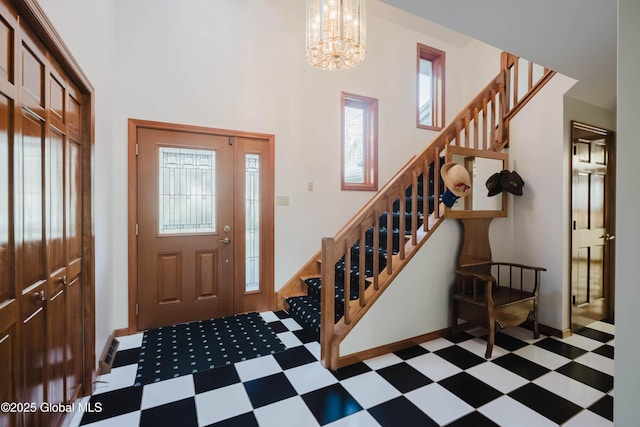 foyer featuring tile patterned floors, a healthy amount of sunlight, and stairway