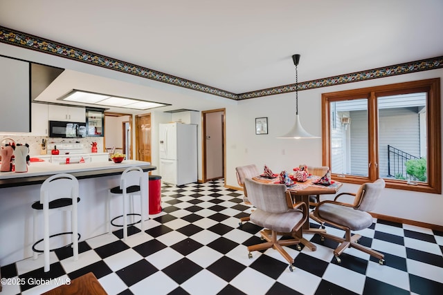 kitchen with a peninsula, black microwave, baseboards, white refrigerator with ice dispenser, and tile patterned floors