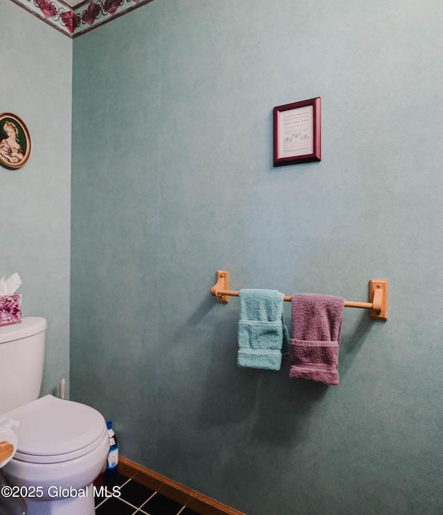 bathroom with baseboards, tile patterned floors, and toilet