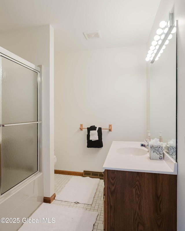 bathroom featuring visible vents, vanity, baseboards, toilet, and enclosed tub / shower combo
