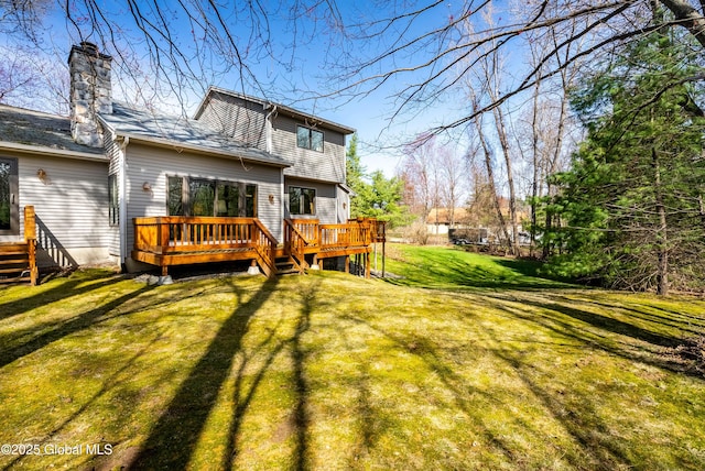 back of house with a chimney, a yard, and a deck