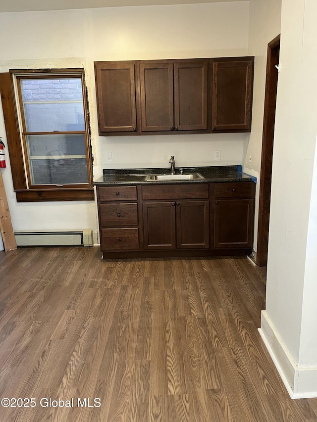 kitchen featuring dark brown cabinetry, dark wood finished floors, a sink, and a baseboard radiator